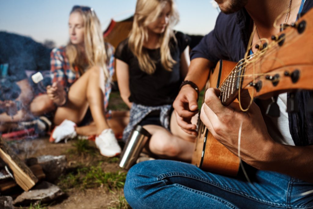 A group of friends enjyoing their self's while playing a guitar and listening to it By Music School In Oak Park.