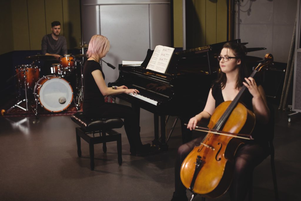 The three person having and enjoyable time and spent their time on playing their instrument.