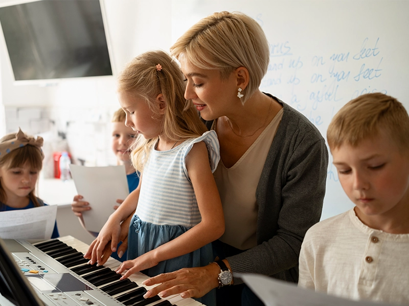 A woman teacher teaching her students on how to play instrumentsOak Hollow Park.