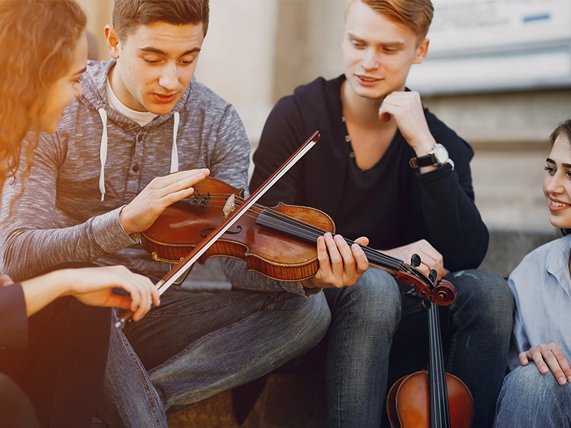 A group of adults enjoying their selfs while the one adult playing a violen By Music School In Oak Park.